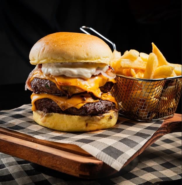 Hambúrguer artesanal duplo com cheddar e cesta de fritas do Chama Burger & Steak
